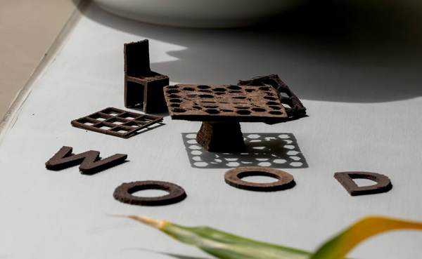 Výber z 3D tlačených drevených predmetov, vrátane miniatúrneho stolíka a stoličky.