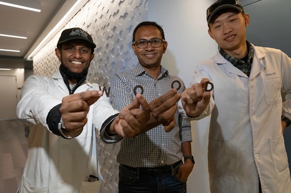 Členovia tímu M.S.H Thakur, Muhammad Rahman a Chen Shi (zľava doprava) pózujú s 3D tlačenými drevenými písmenami vyrobenými v rámci štúdie.