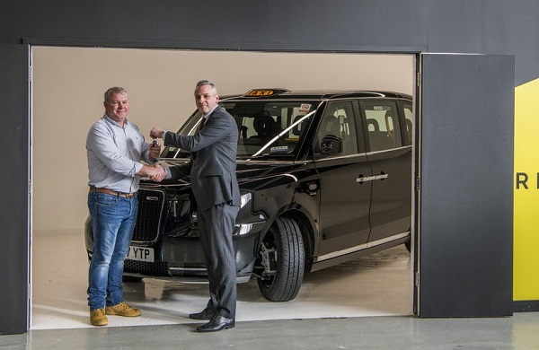 Londýnsky taxikár David Harris preberá kľúče od svojho nového elektrického taxíka TX od Lorenza Bugliariho zo spoločnosti London EV Company.