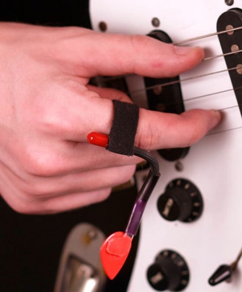 Pick Slinger je šikovný držiak pre gitarové brnkátko, ktoré sa tak nestráca počas prechodu hrania prstami